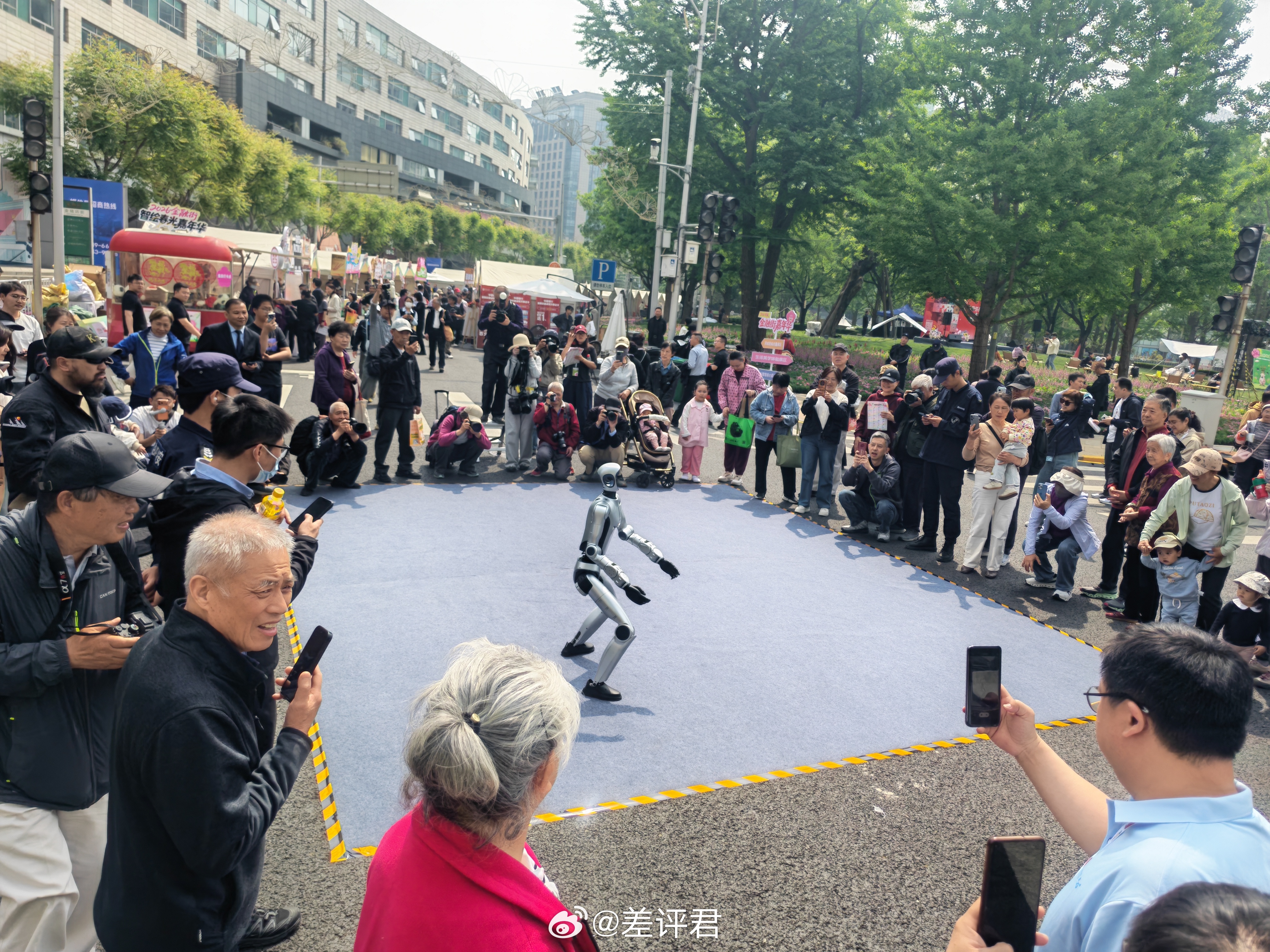 在亦庄机器人马拉松比赛上杀疯了的荣耀机器人，又去金融街溜达了。一直在跟老人小孩互