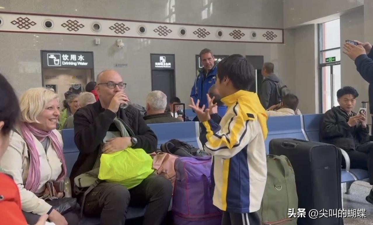 从吉隆坡回来带儿子父母去四川九寨沟旅游，在高铁站儿子遇到一个外国旅行团，等车的功
