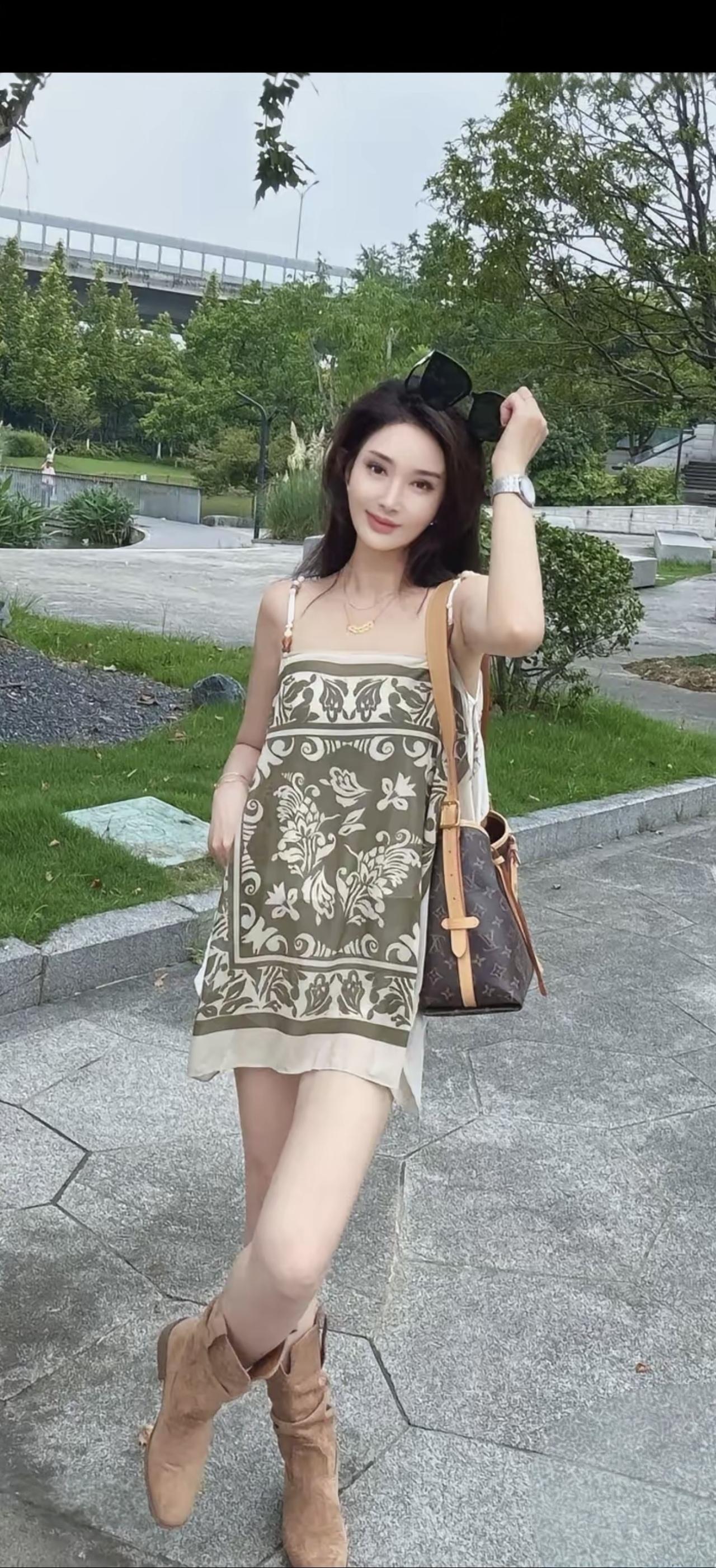 穿花裙子的美女在公园拍照。