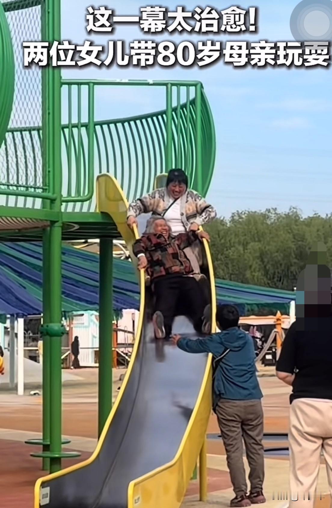谁规定滑滑梯是小朋友的专属？这一幕太治愈了

近日，一位80岁老奶奶被两个女儿带