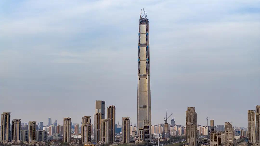 天津117大厦近在做顶部的钻石💎冠部，工作人员正在吊装顶上钻石形装饰的钢材框架