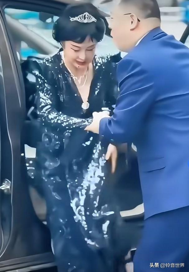 被工作人员扶着下车的美女，仪态雍容华贵，却掩盖不知内在的端庄淳朴，虽过古稀之年，
