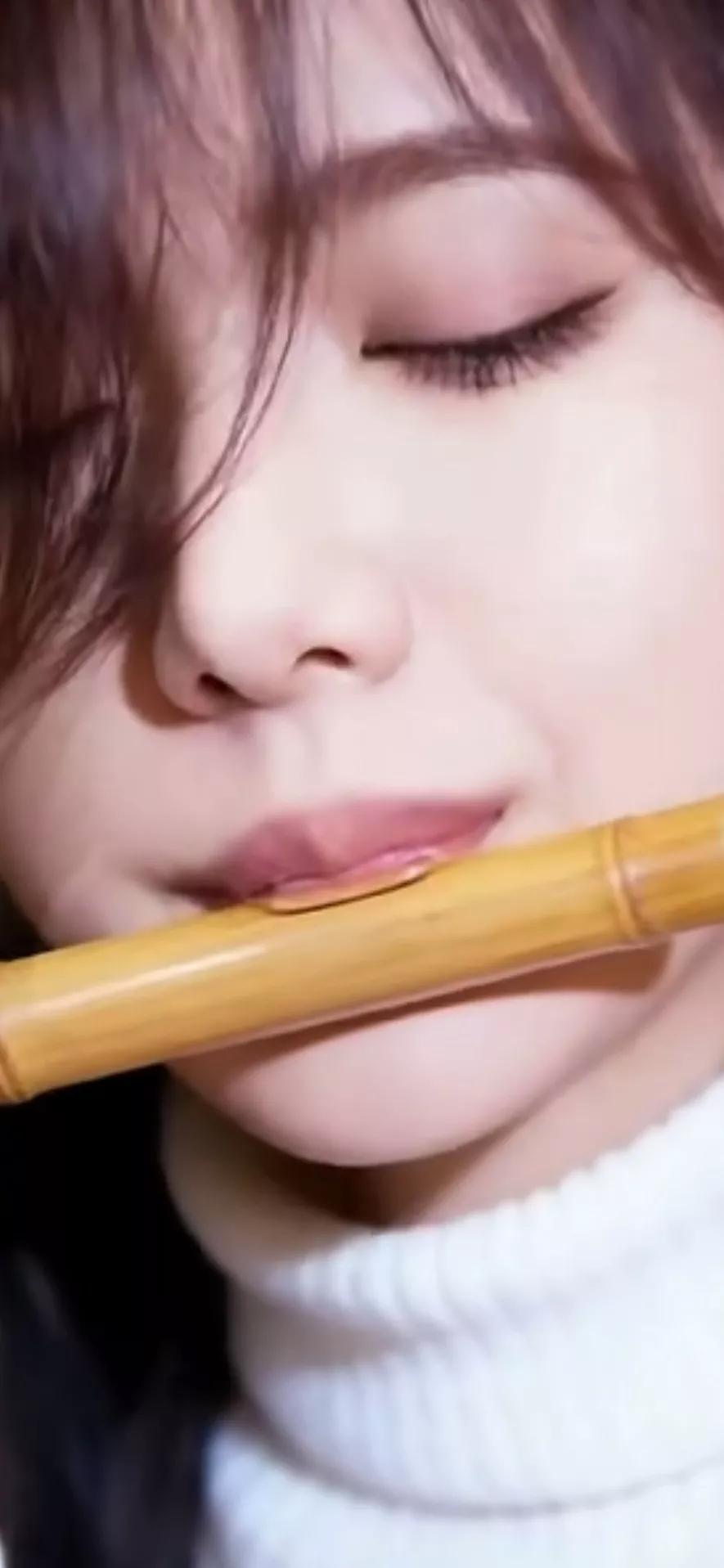 闭眼吹笛，沉醉在音乐的世界里。
温柔甜美少女 古典温婉美女