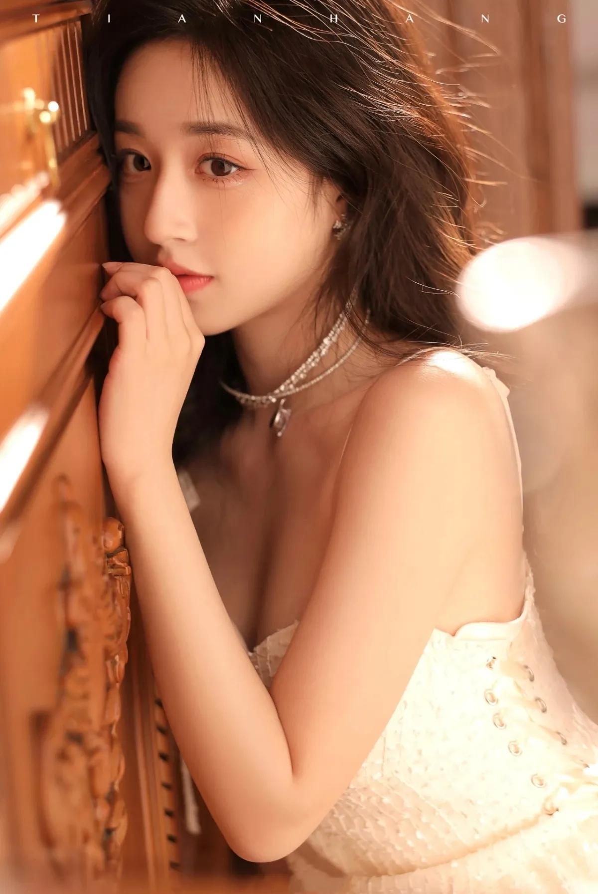 裙摆铺地如月光漫延，
木柜的影，轻咬着纱边，
琴靠膝头，和时光并肩，
弓垂腕底，