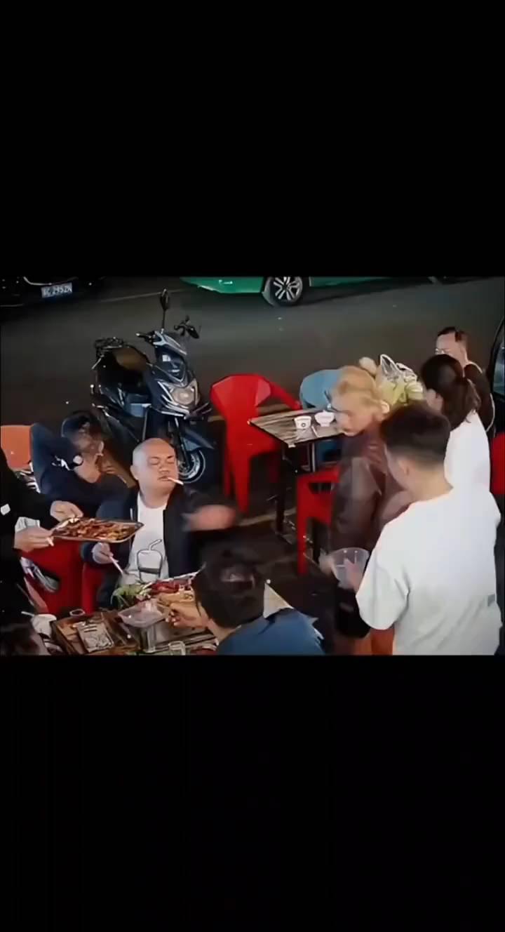 光头大哥在外聚餐，看见了一名跛脚男孩站着，于是要来餐盒，将肉装的满满的。男孩已经