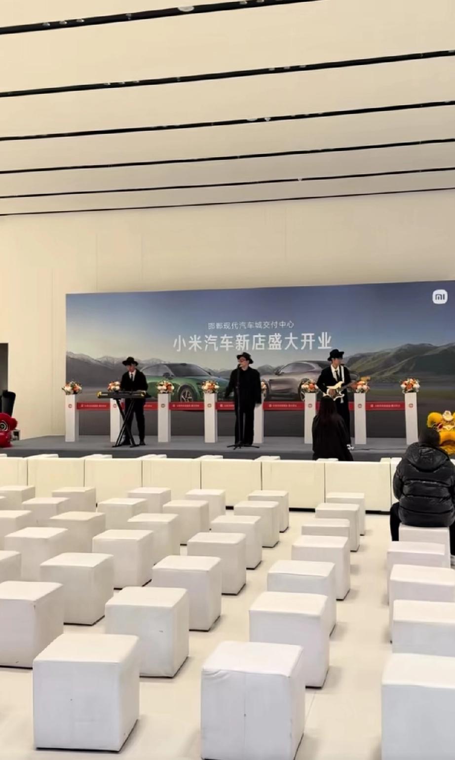 河北邯郸，小米汽车现代汽车城交付中心盛大开业。台上歌手在卖力的演唱，可貌似到场的