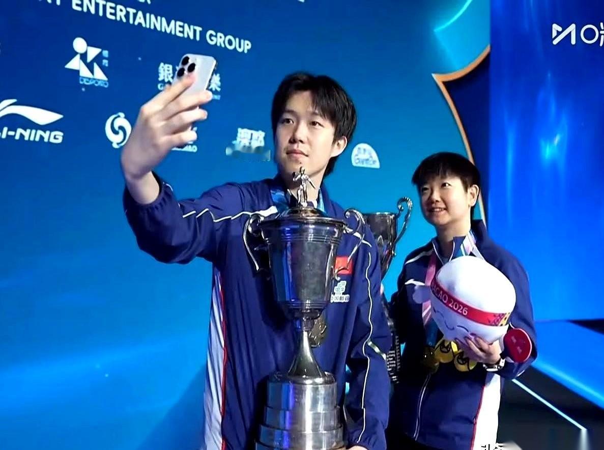 兄妹俩，刚站上领奖台，又杠上了。
哥哥往前一递手里的吉祥物，意思很明白：你拿着。