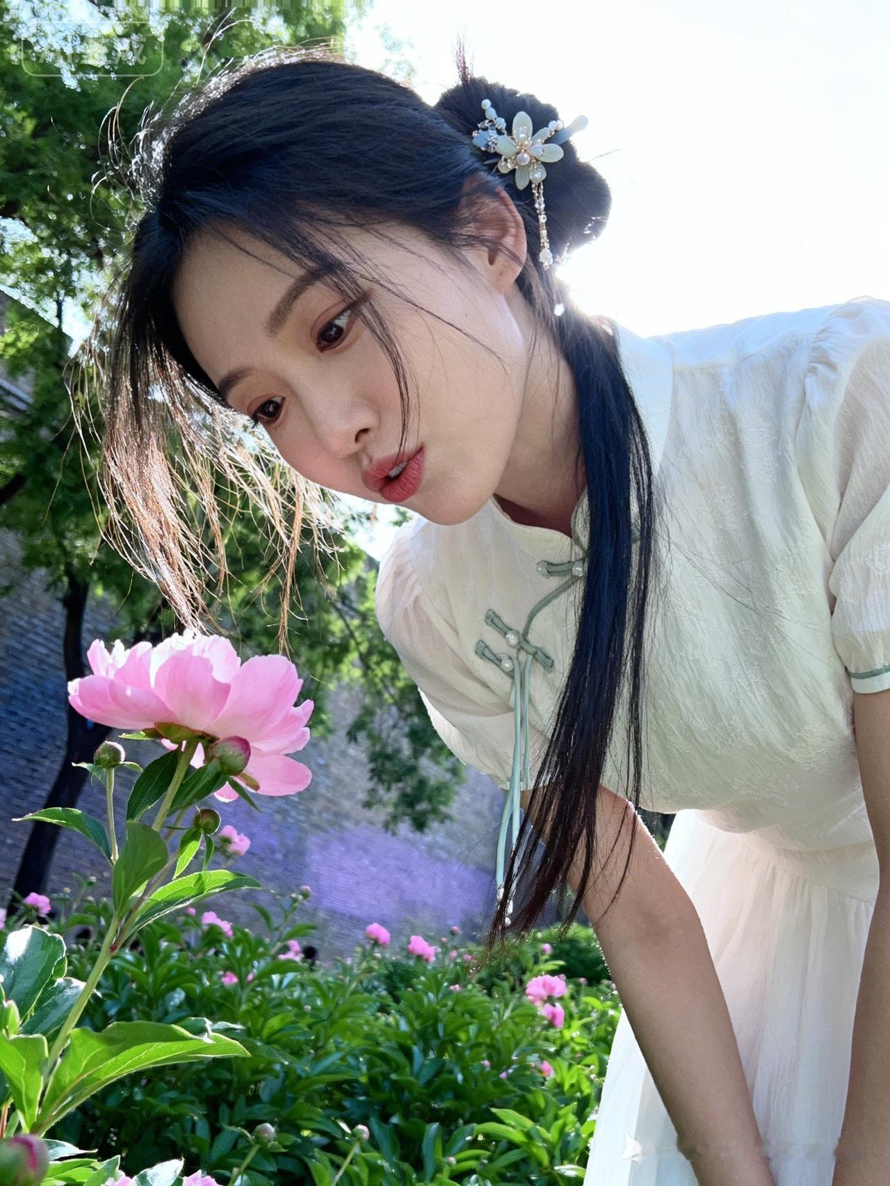 28岁女学生着白色纯棉雪纺裙，缀精致古风发饰，弯腰赏花，俏皮慵懒，鬓角碎发自然凌