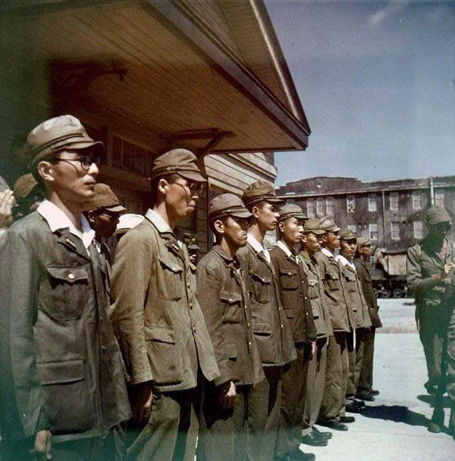 1945 年 8 月 30 日，日本横须贺海军基地投降期间，日本人员列队站立。