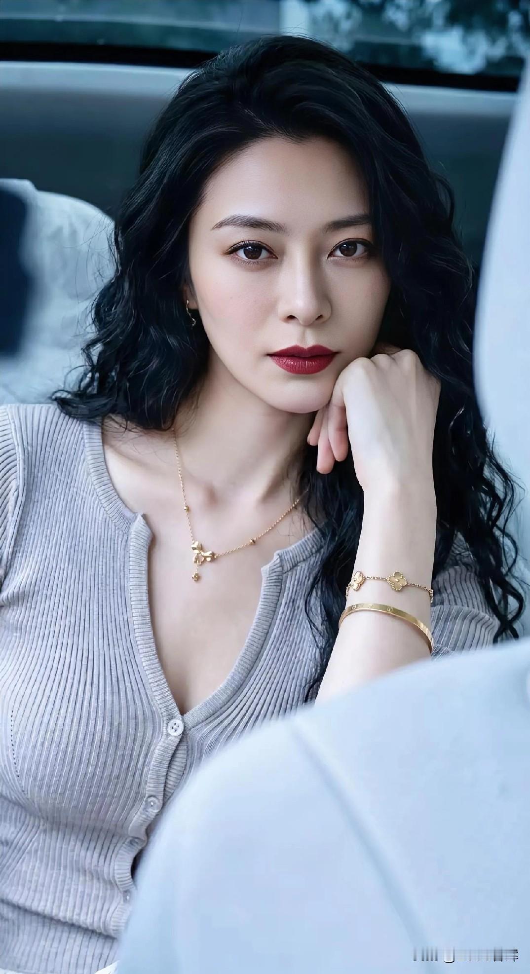 灰衫拥柔光，金饰缀静芳。

发卷如墨漾，手托腮思长。

车隅藏思绪，美在凝眸间。