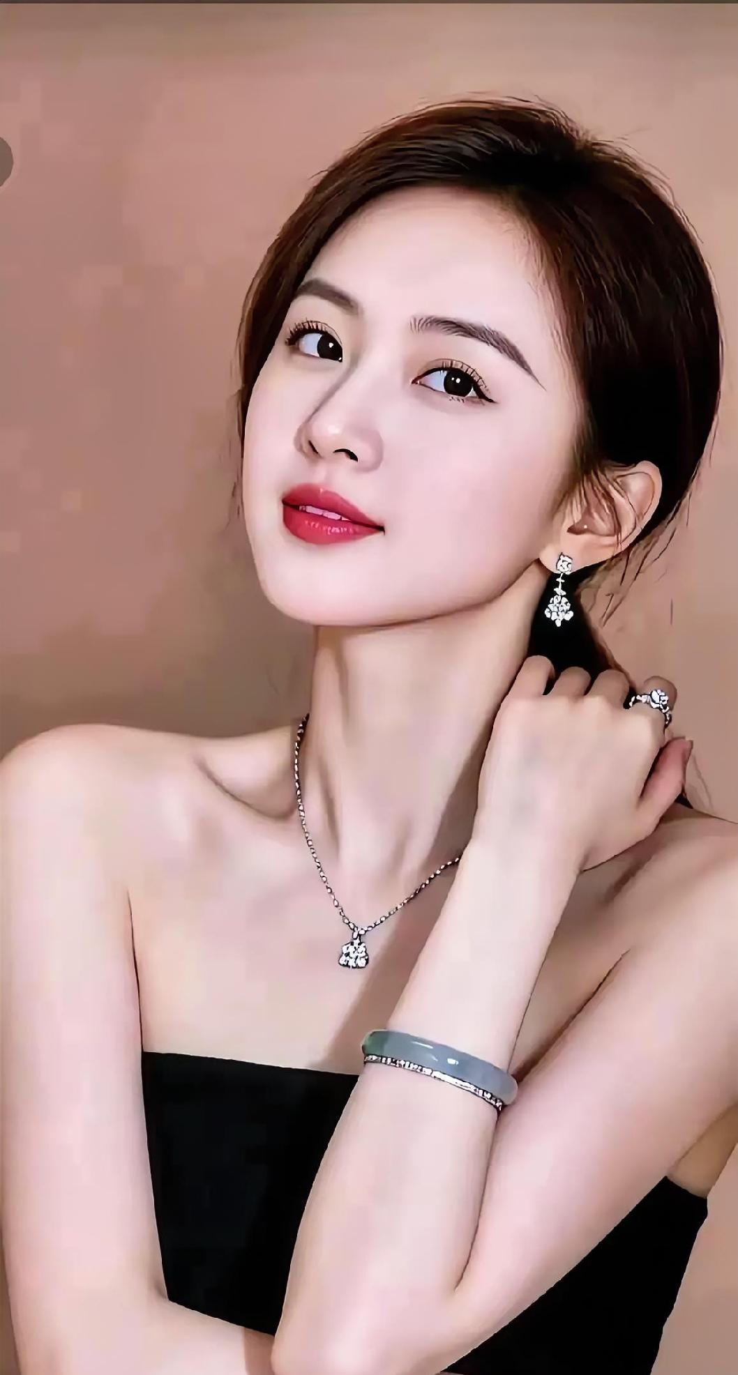 她抬眼的瞬间，风也温柔。

黑裙衬玉颈，银链坠星光，

耳畔轻摇碎梦，腕间浅碧生