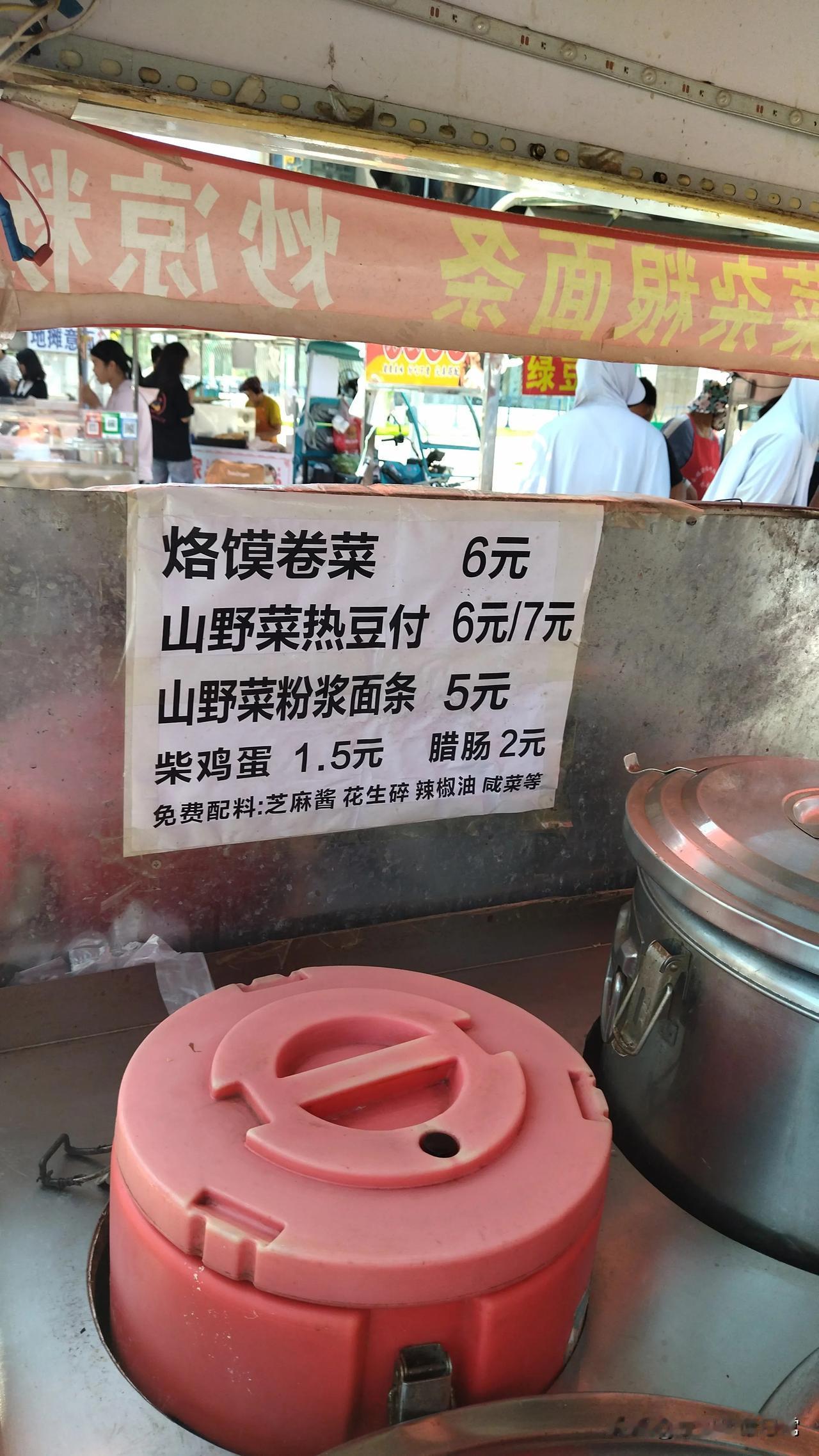 公司附近有一个卖山野菜热豆腐的小摊位，夫妻俩一起，丈夫卖热豆腐，妻子卖烙馍卷菜。