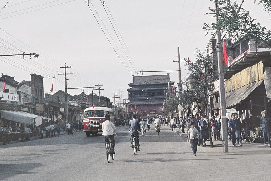1967年的北京鼓楼大街，远处灰瓦重檐的鼓楼稳稳立在街的尽头，木质楼阁的古旧纹理