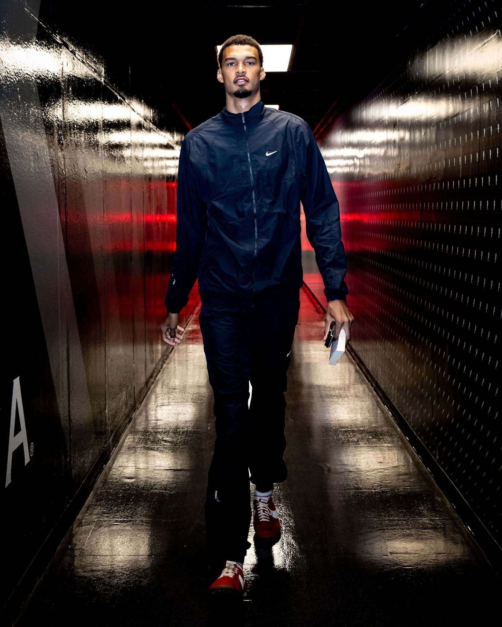 【球员通道照出来了，马刺开工👽】文班穿深蓝运动外套，手里捏着张纸条，一个人从通