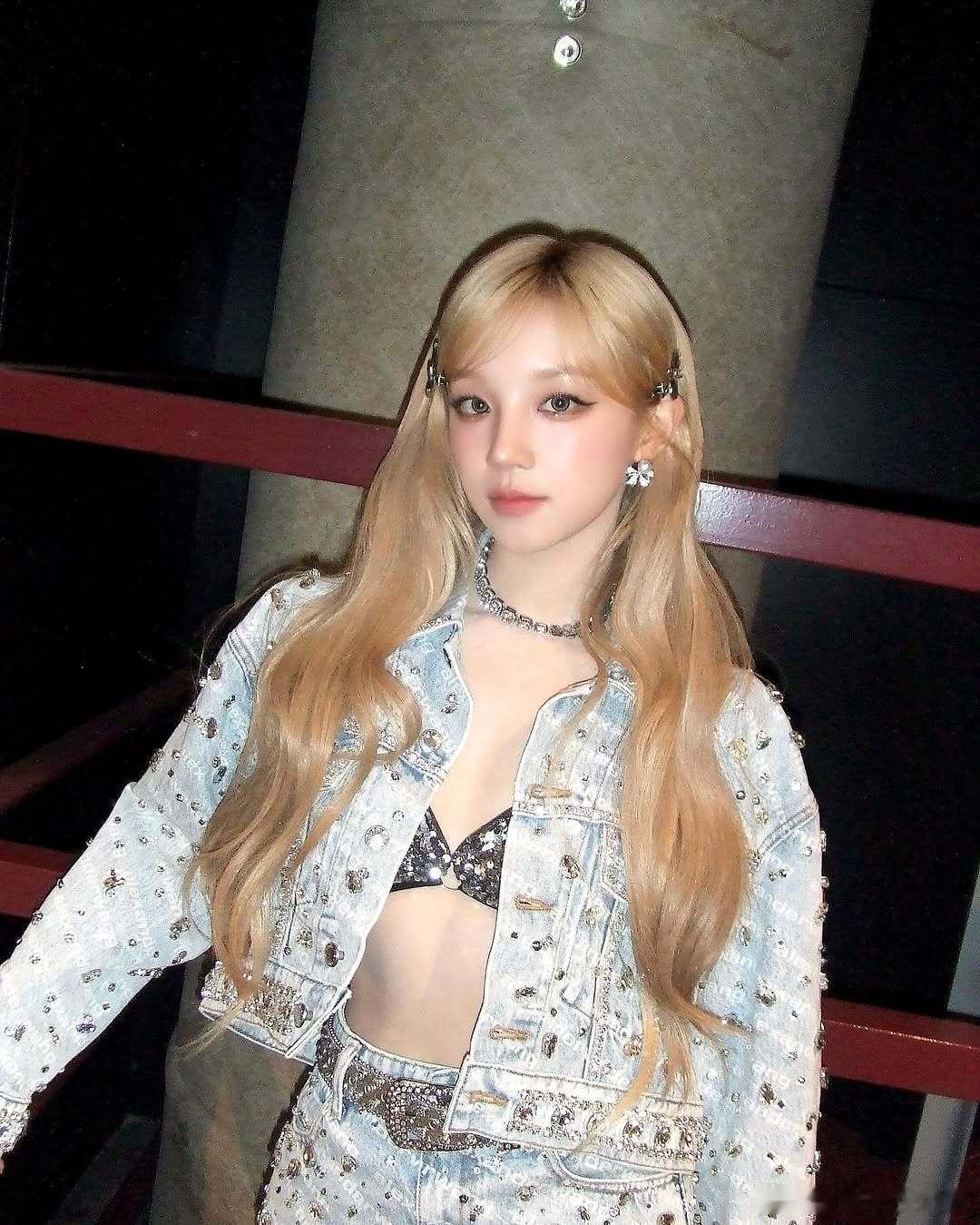 蓬松的金发梢沾着细碎的金粉，收腰礼服上的刺绣在光下流动，她笑起来时，酒窝里像盛着