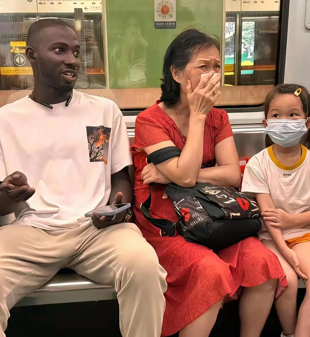 地铁里看到的，为啥黑哥们儿旁边的大妈这种表情？