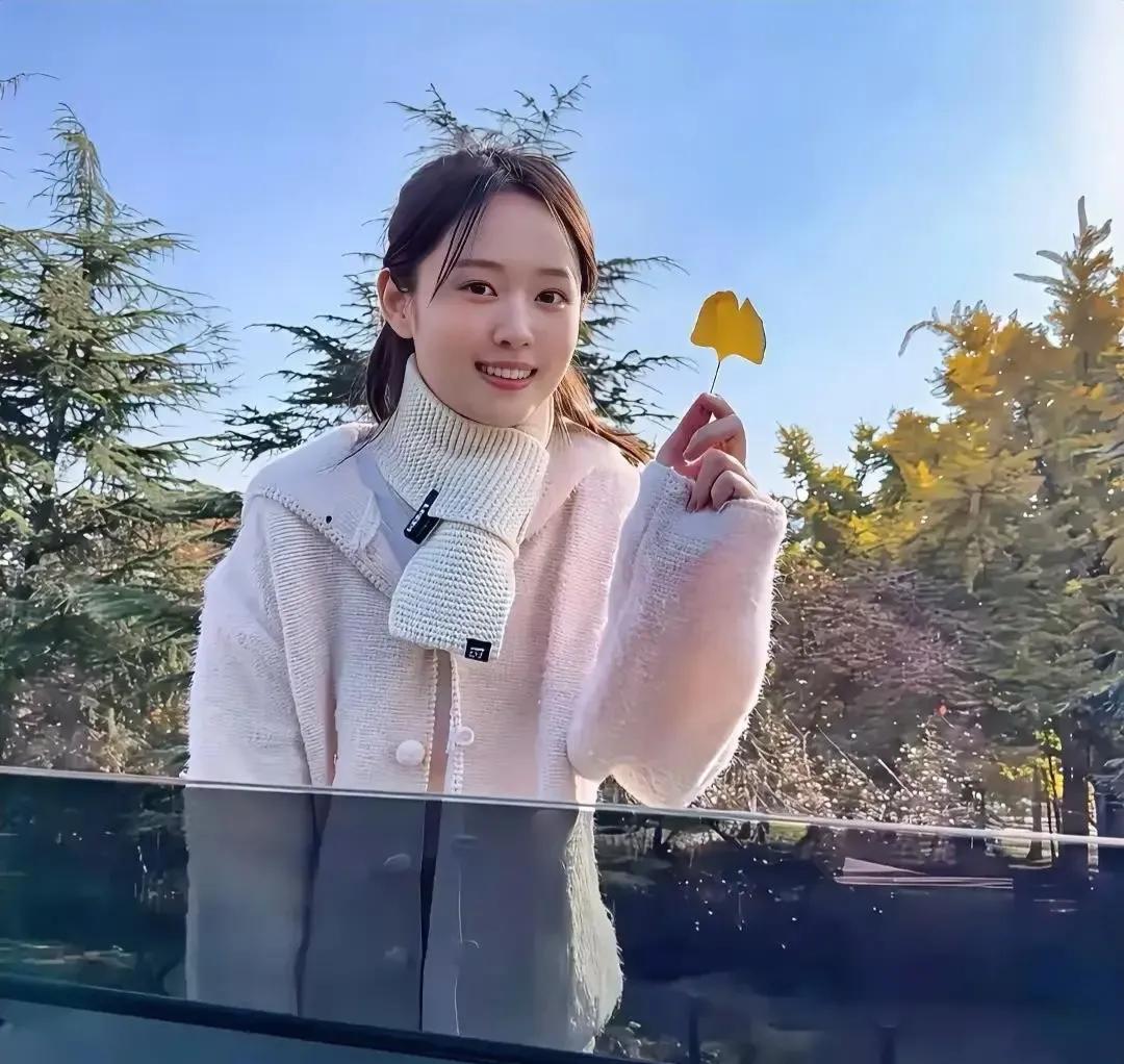 刷到这张图瞬间梦回青春校园——扎着低马尾的清纯女孩，笑眼弯成月牙，手里举着片金黄