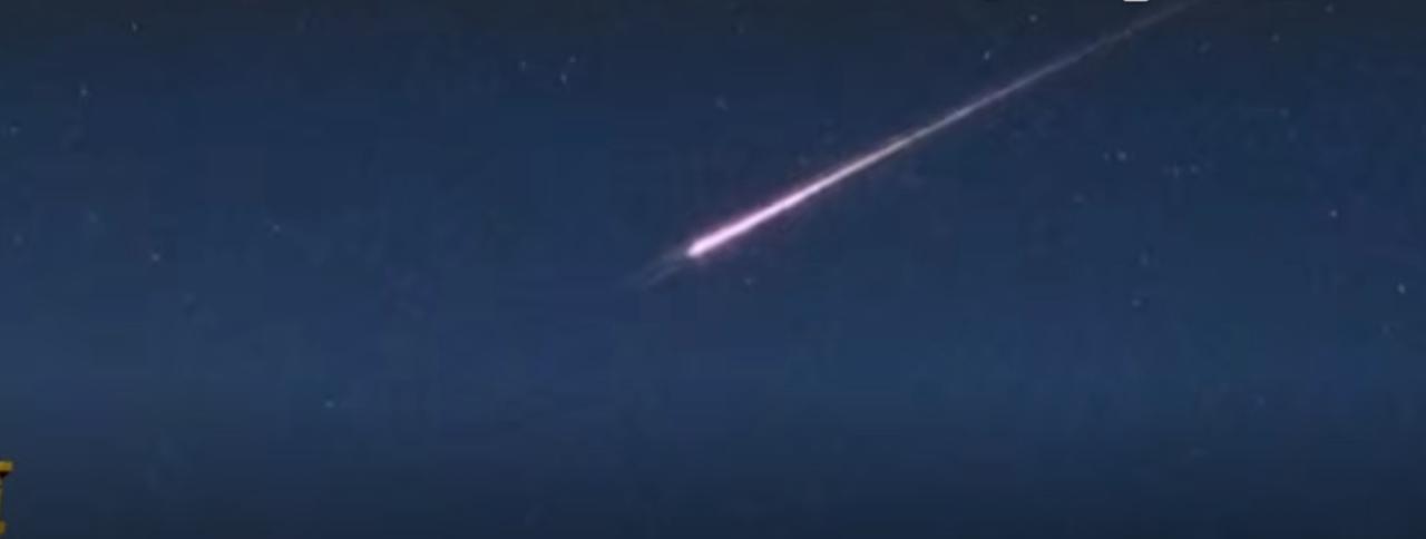 深邃的夜空中，一道亮粉色的光带划破天际，拖着长长的尾迹飞速坠落，随后在城市上空炸