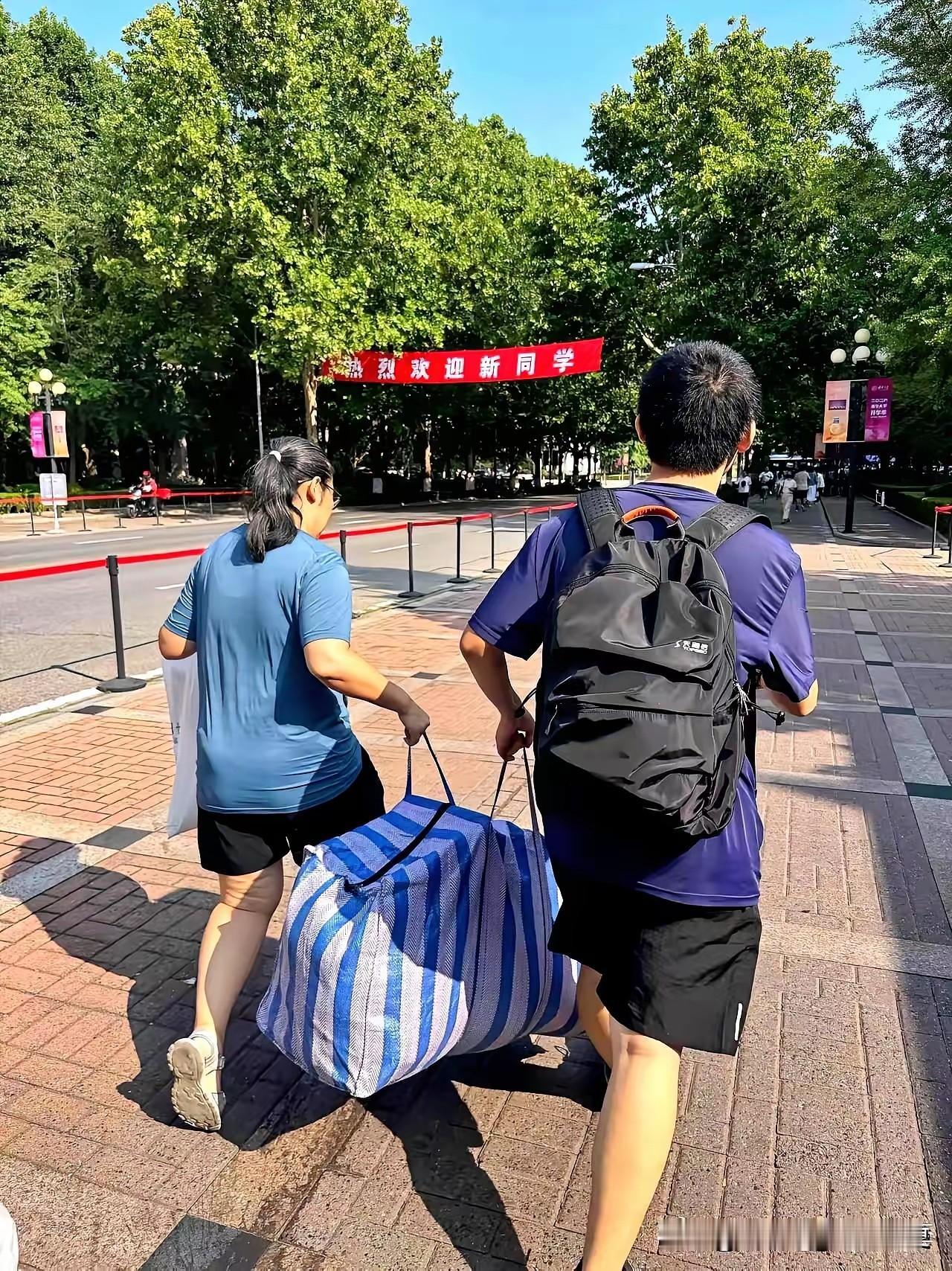 清华大学2026级新生报到现场，我被一幕深深打动：一位新生和母亲抬着一个破旧的“