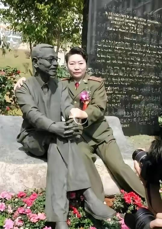 1997年，陈景润的夫人坐在丈夫的雕塑旁边，搂住“丈夫”的肩膀，留下了这张令人垂