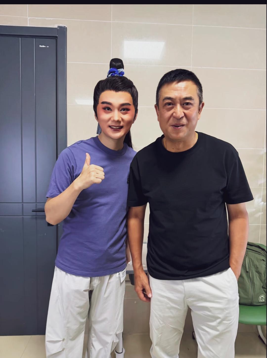 张嘉益留着寸头神色，一只手插裤兜，简约黑色圆领短袖，白色休闲长裤，风格低调。不演