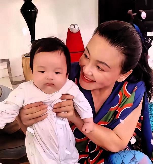 张兰抱小孙子, 孩子很结实, 她笑得开心, 脸上都是满足, 这种心情真好, 好像
