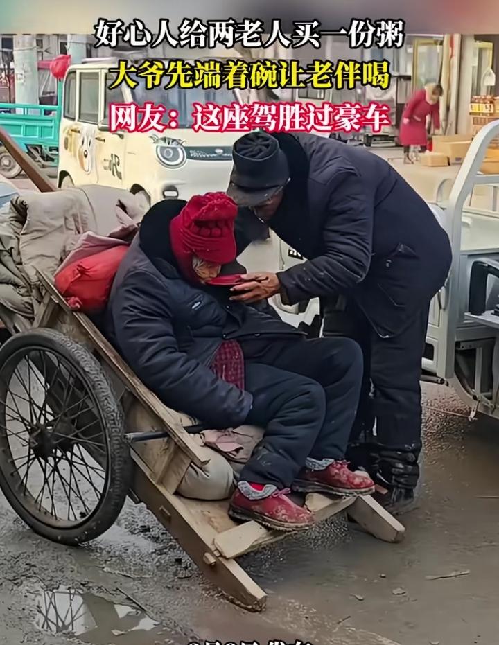一大爷用老式平板车拉着大娘上街， 好心人给两个老人买了一碗粥，大爷小心翼翼地捧着