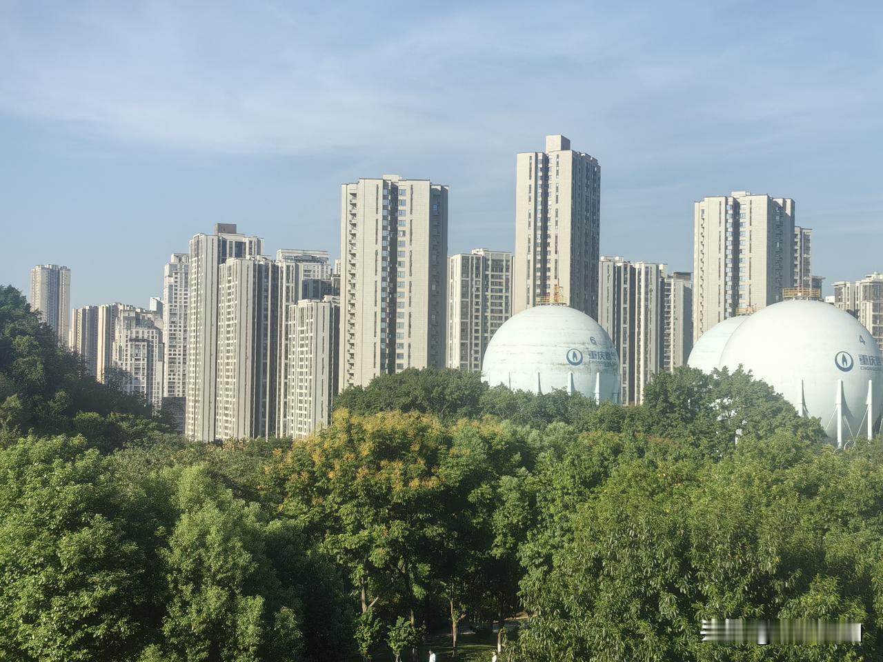 城市高楼林立，绿树掩映着气罐。