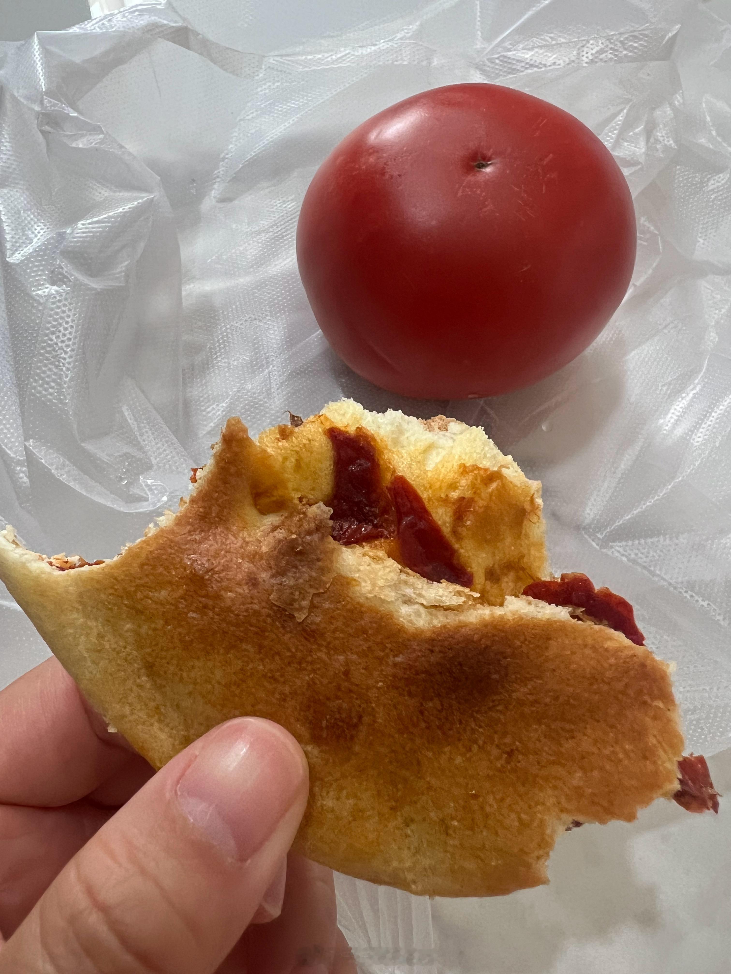 今天早餐。辣皮子馕和一个西红柿。昨天买一个西红柿的时候，收银小哥都楞住了。购买的