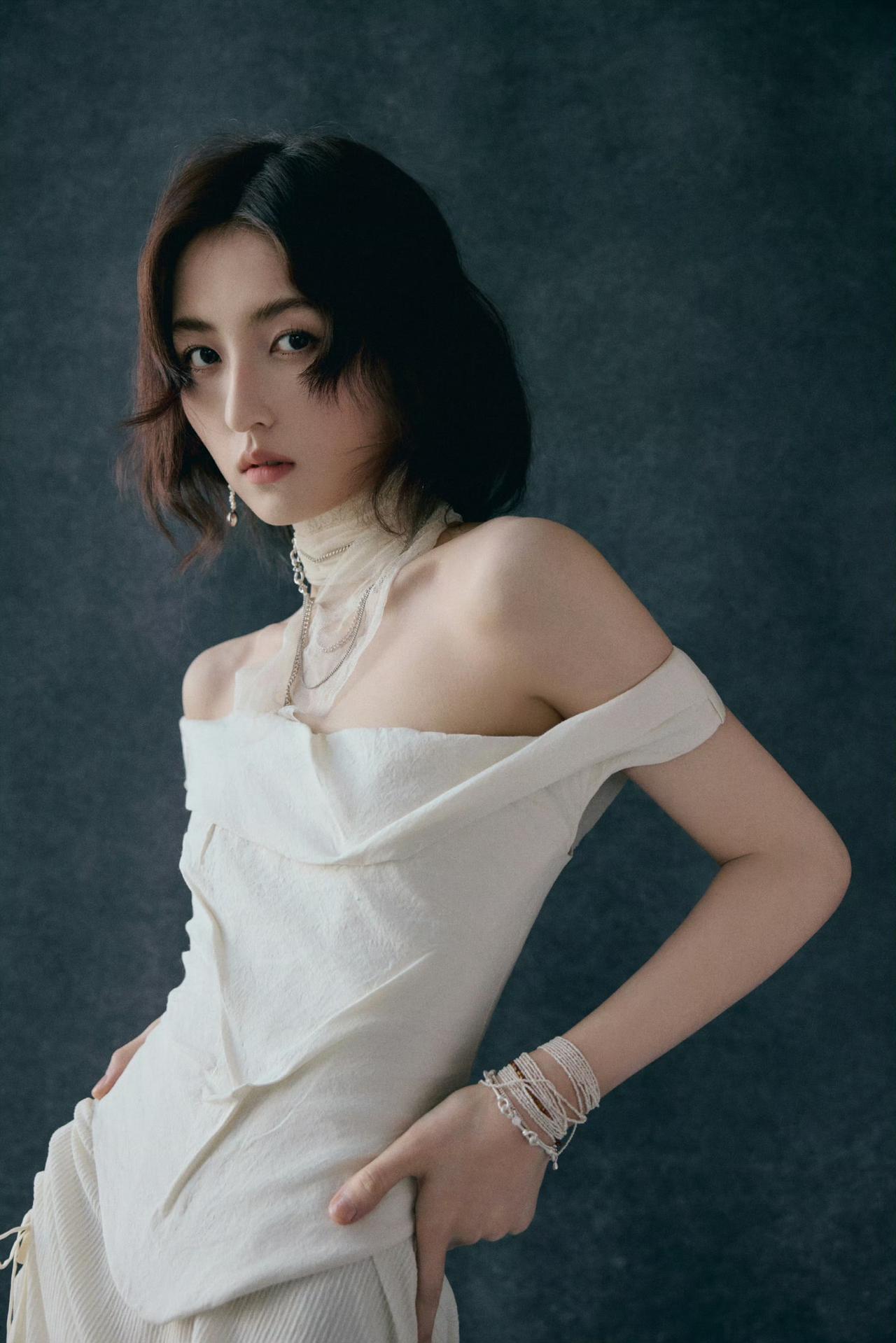 张子枫工作室晒出她在CMG中国电影盛典红毯造型：她穿着一件白色的露肩连衣裙，肩部