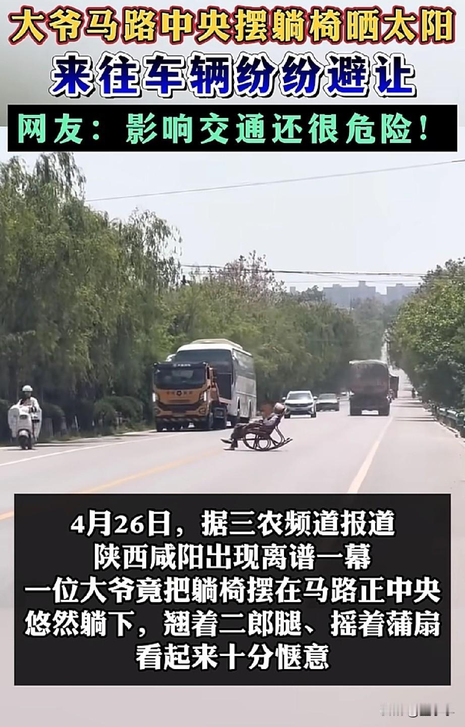这是把马路当成自己客厅了？
陕西咸阳，一老人躺在马路中央晒太阳，翘着二郎腿，摇着