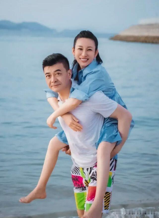 55岁的王新军在海边背着47岁的秦海璐一起玩，两个人还挺浪漫的，这个年龄了还这么