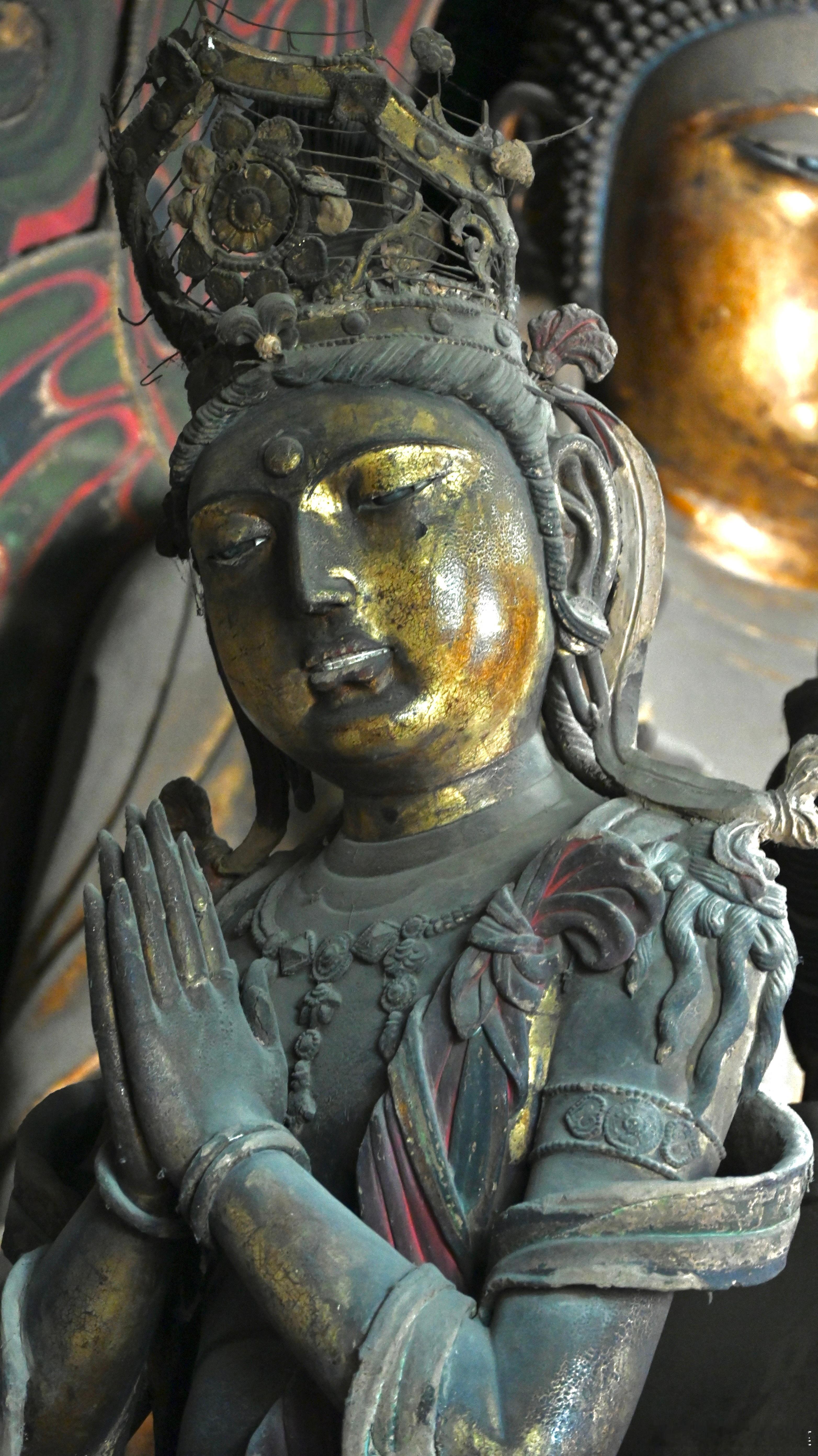 下华严寺薄伽教藏殿合掌露齿菩萨，高3.06米，头戴镂空花珠三角形高华冠。双手合十