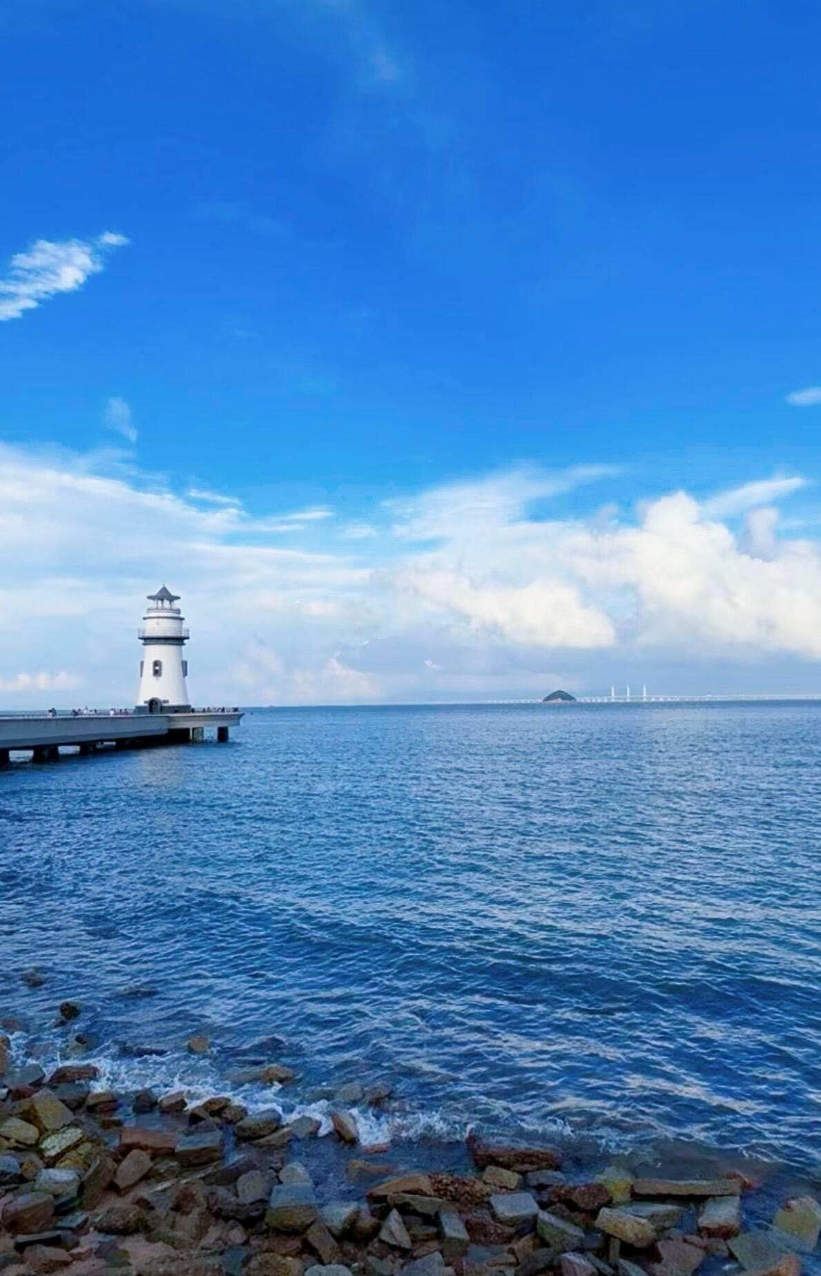 夏日的海风裹挟着温柔，珠海爱情邮局旁的灯塔与无垠大海相映成趣。在天气晴好的日子里