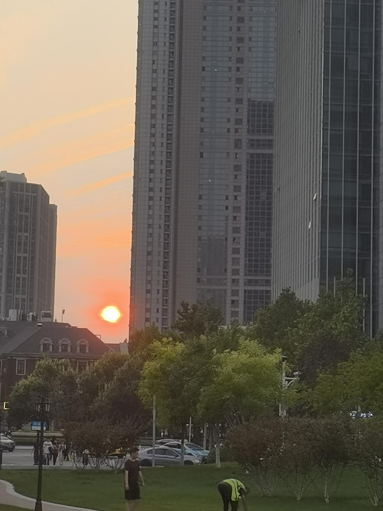 周末傍晚无事休闲，我来到楼下的公园散步，无意中抬头，看到了这一轮红日，正缓缓地隐