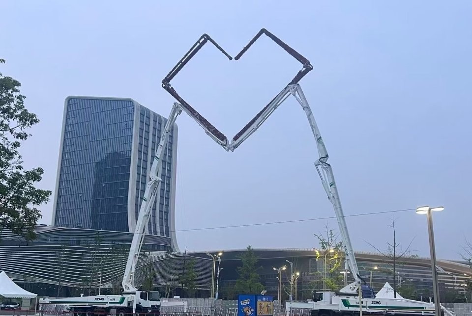 苏超徐州队迎来硬核应援徐工集团大手笔作品，在徐州奥体中心用工程机械拼出巨型心形拱