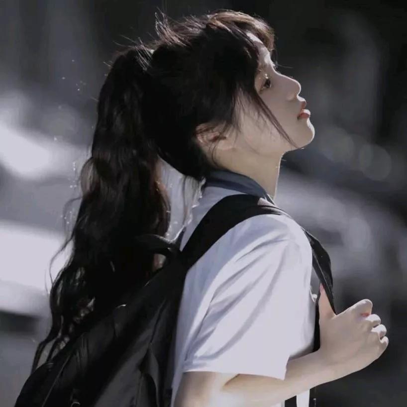 校园里的美好时光，少女背着书包，享受阳光的温柔。阳光少女照 少女的背影 校园里的