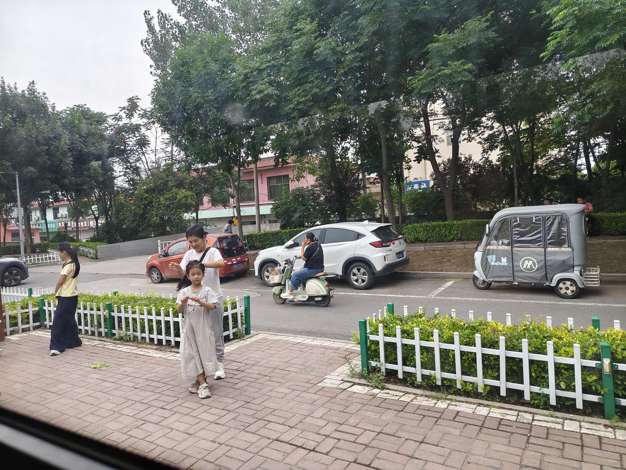 您瞧瞧，在运城盐湖街上，路边一位妈妈趁着等公交车的空闲，赶忙给女儿梳个漂亮发髻。