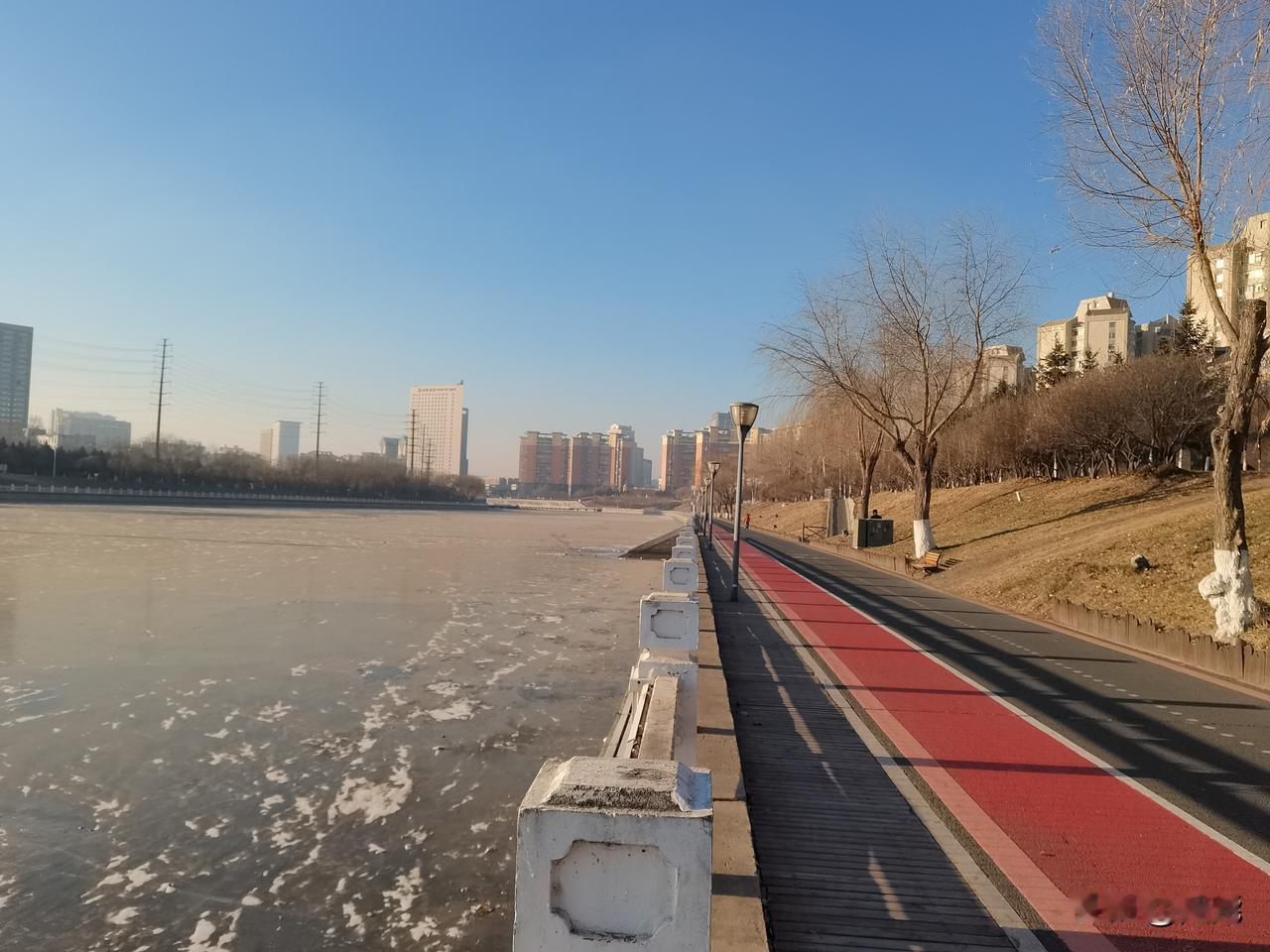 冰封伊通河，晨光映堤坝。