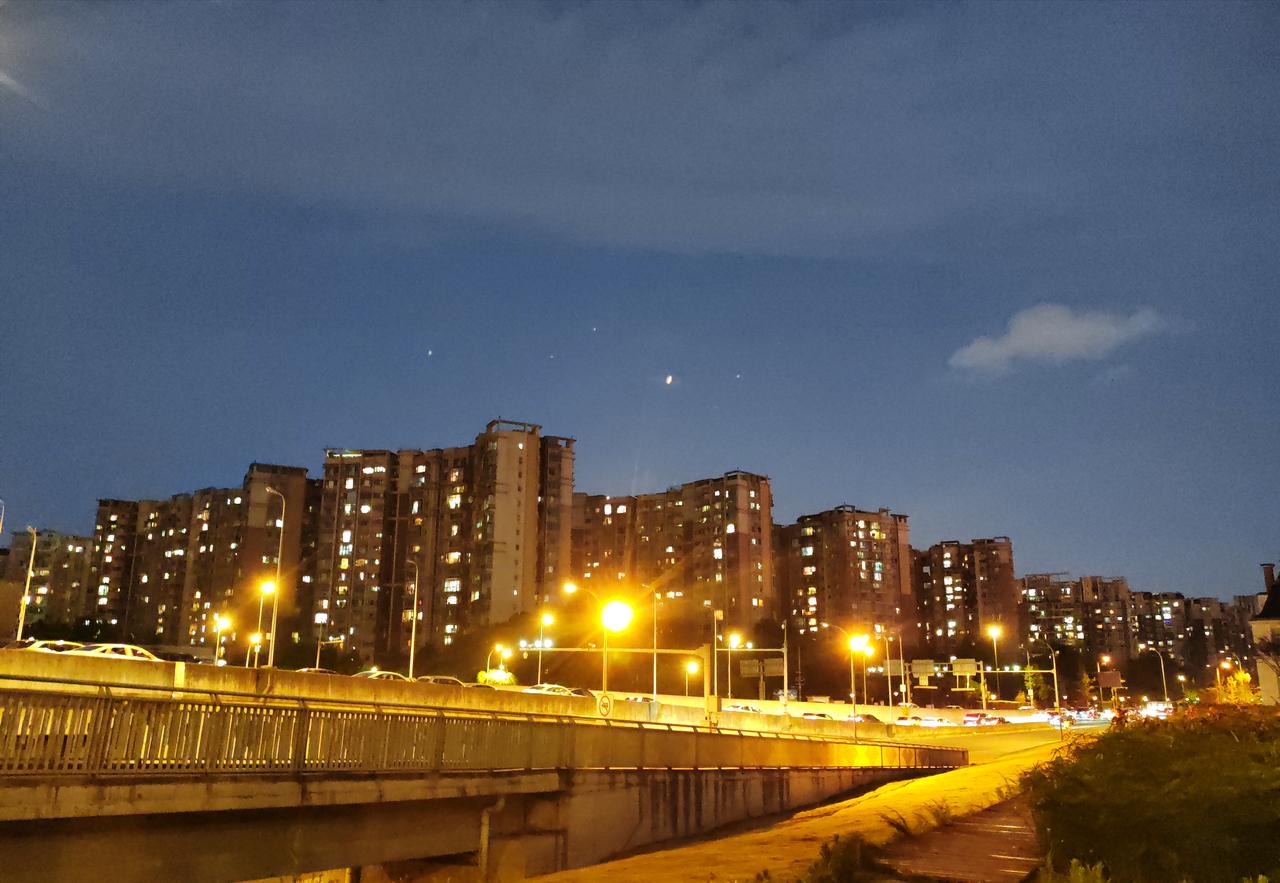 城市的黄昏总是很短暂，一转眼，暮色就铺满了天空。路灯次第亮起，车流在高架上缓缓流