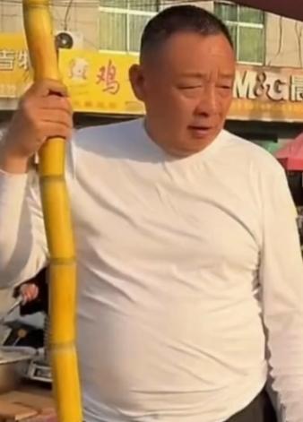 有网友偶遇退休的于东来，在老家街边卖甘蔗，他衣着朴素，十分接地气。

看到路人围