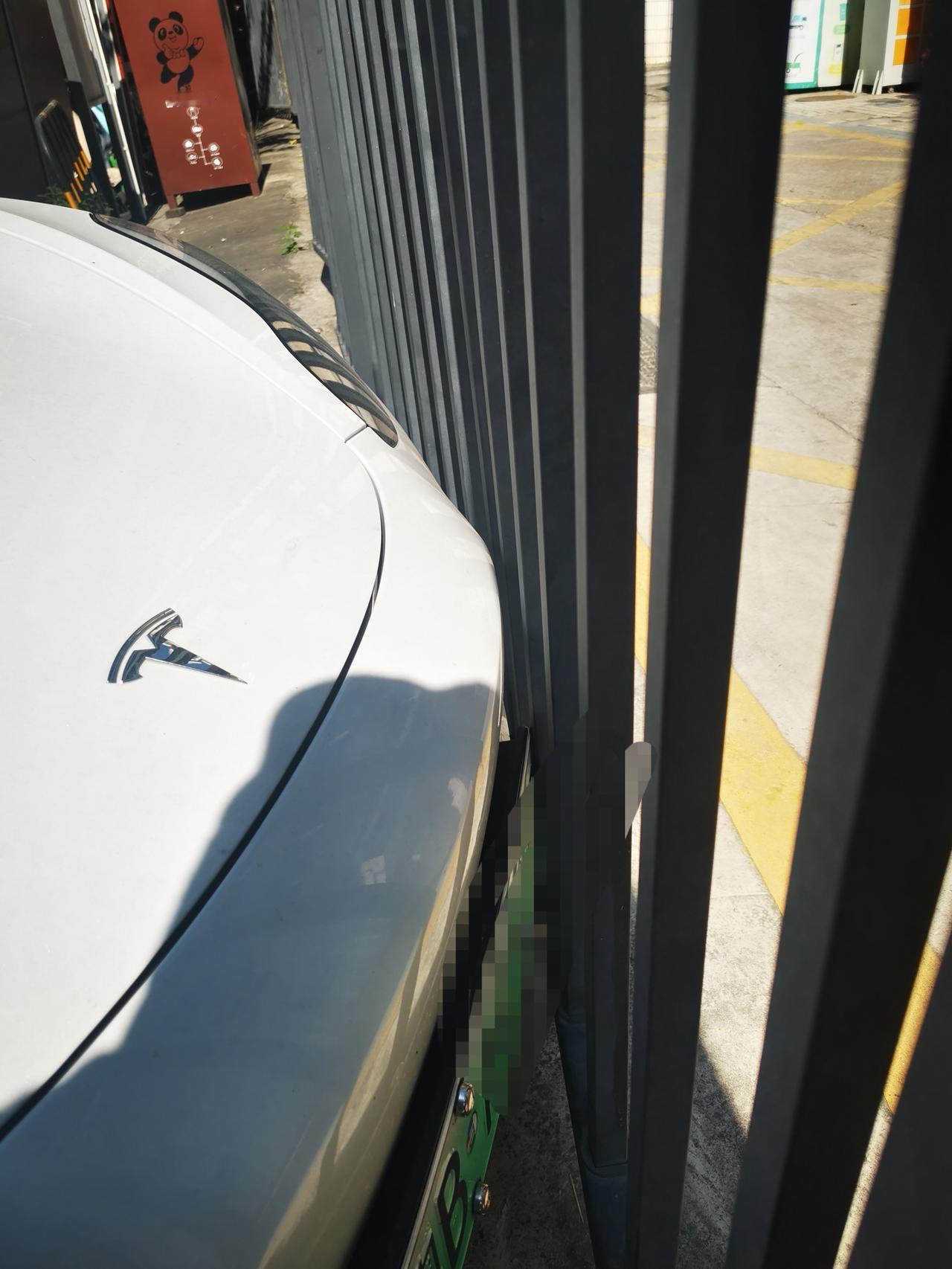 这是没刹住？大老远看到这辆白色的特斯拉紧紧的顶着前面的栏杆，我还赞叹车主的停车技