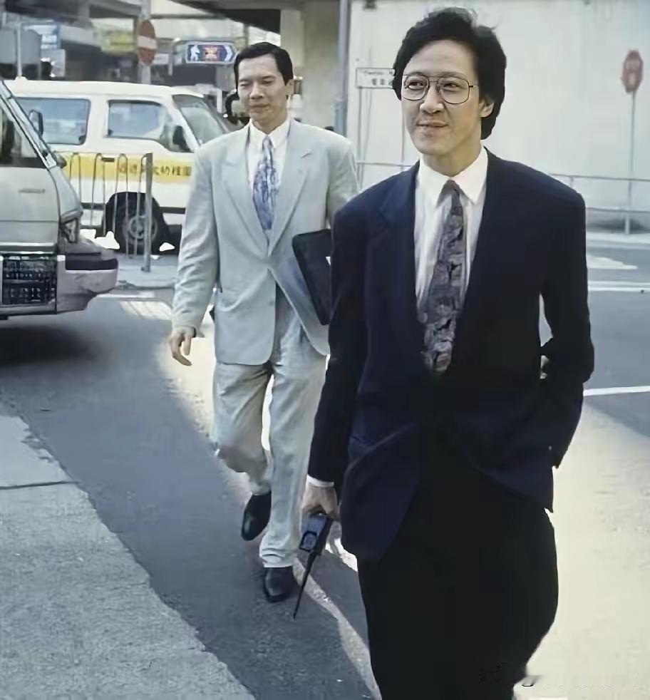 拿包的是哥哥，拿大哥大的是弟弟
他们是同父异母的兄弟

关于他们的传言有很多，最