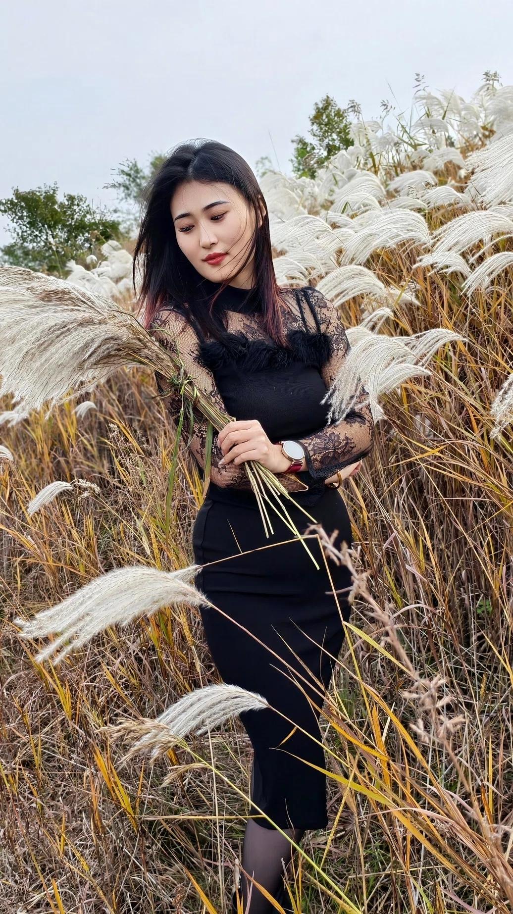 在秋天的田野里，黑裙少女与芦苇共舞