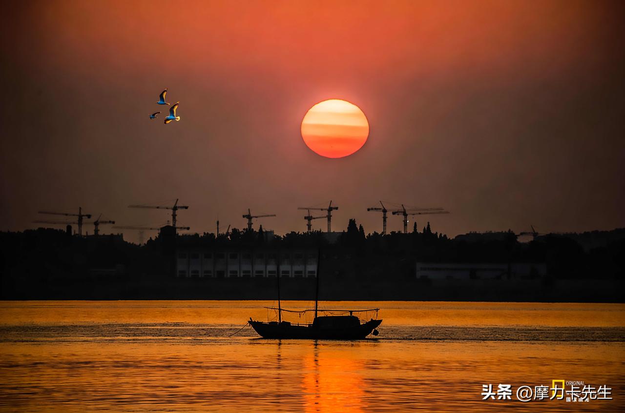 落日燃尽流云，金光铺满江面。舟影浮沉，飞鸟翩跹，山河在壮阔的黄昏里，写尽人间温柔