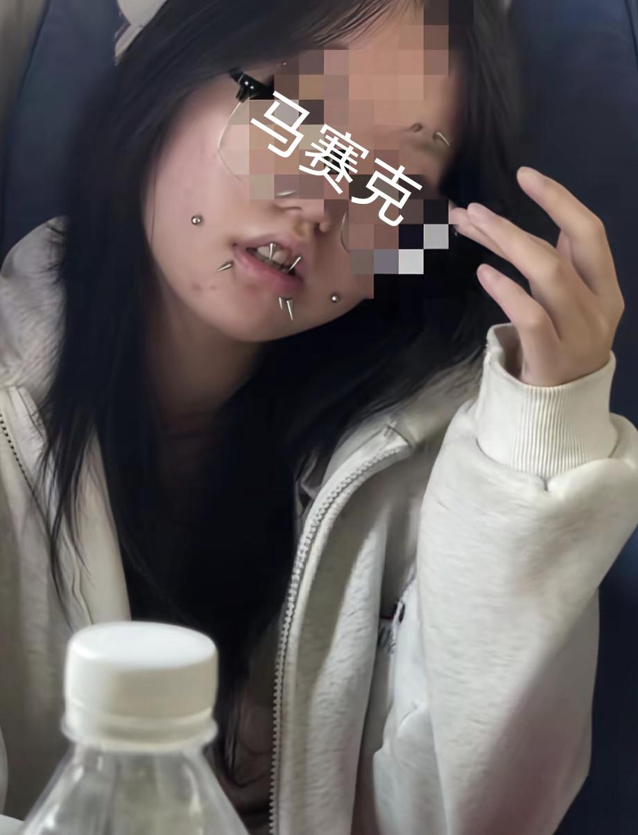 好好一张年轻女孩的脸，硬生生扎满唇钉、脸钉，尖刺朝外密密麻麻堆在嘴周，看着惊悚又