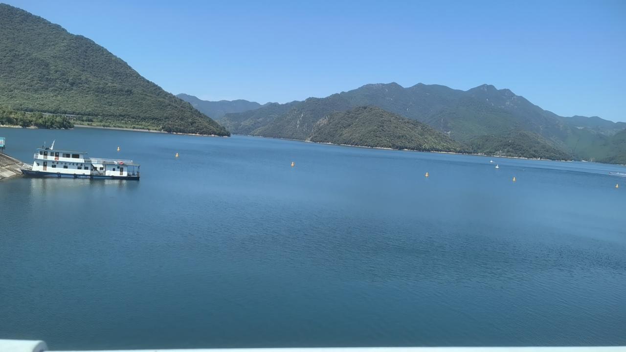 我站在大坝上，坝这边是千岛湖，坝那边是新安江，湖面清澈，约可见底，据说能看到水面