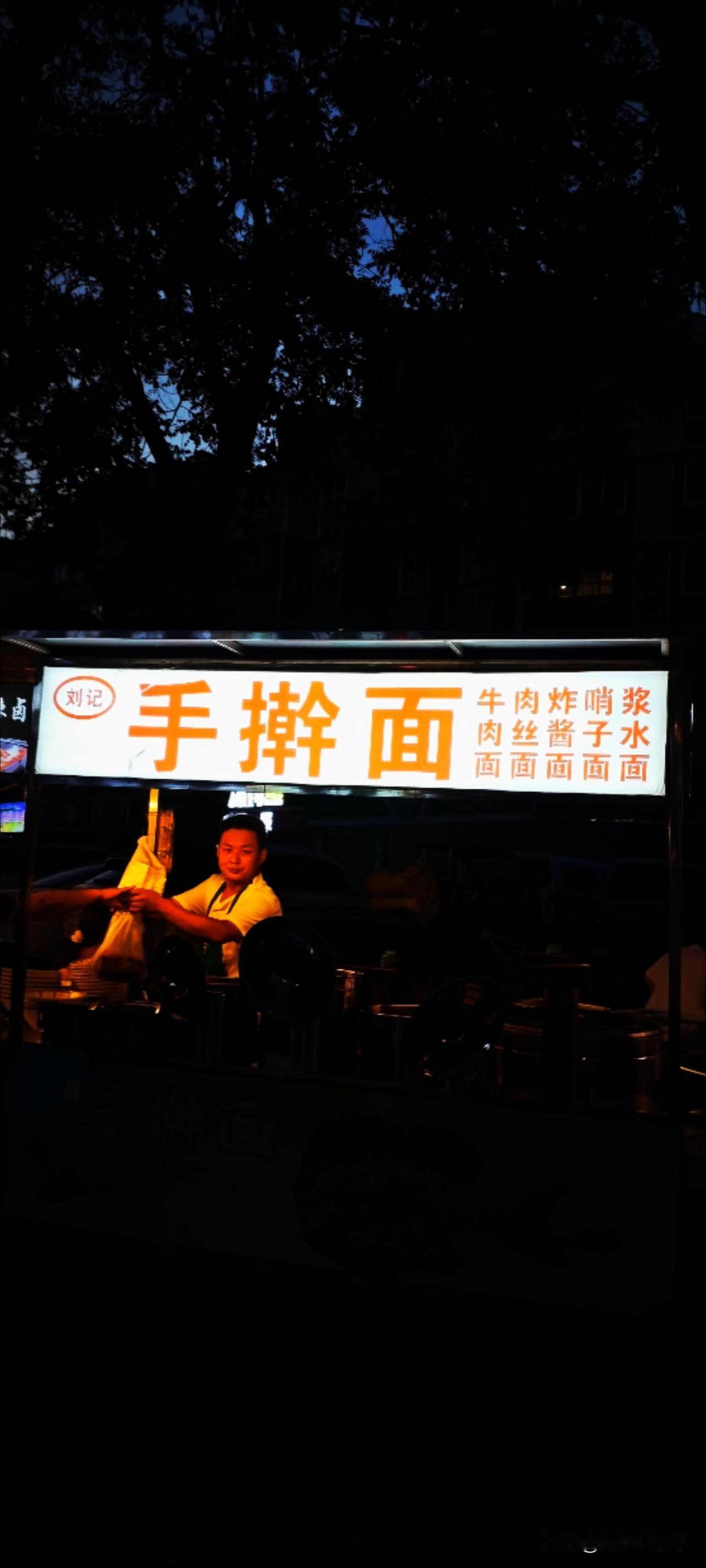 【日与夜：夜】还是晨间的那棵树，此时已是手擀面的摊位。有人说：白天的饮食是为了生