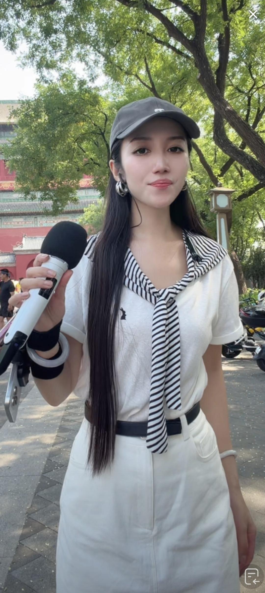 一位女士在户外拿着麦克风。