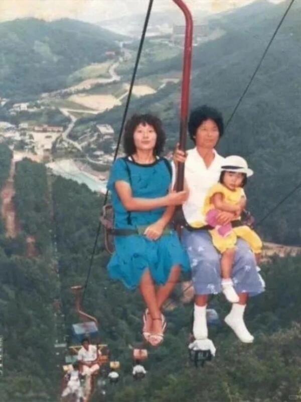 90年代，乘坐缆车游玩的一家人，腰上只系着一根安全绳。

这种缆车看着很危险，实